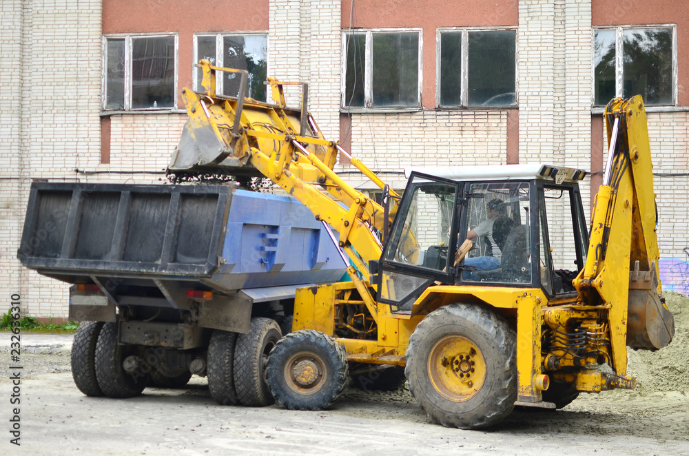 A large Excavator Loading Dumper Truck in the street. Industrial concept A large Excavator Loading Dumper Truck in the street. Industrial concept
