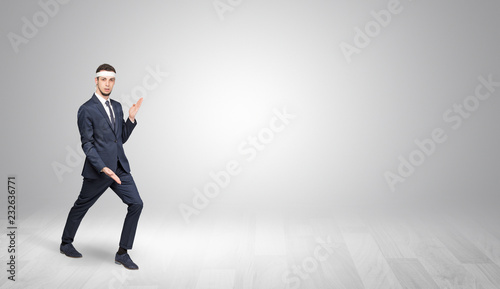 Young businessman in suit fighting in an empty space
