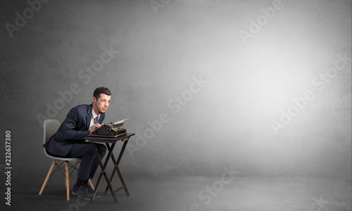 Man working hard on a typewriter in an empty space 