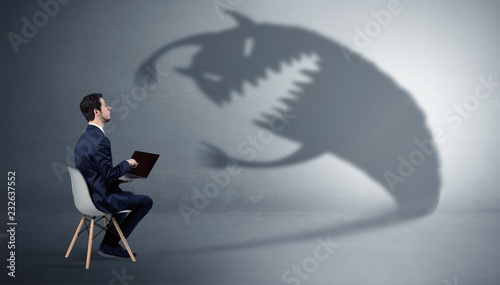 Photography Young businessman staying and  negotiate with a monster shadow