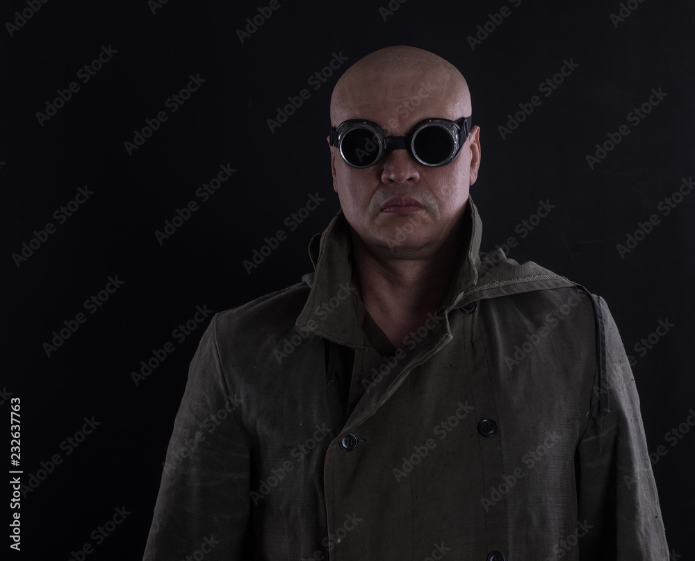 bald man with glasses on a black background