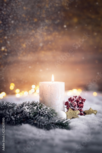 festliches Weihnachtsgesteck mit Kerze im Schnee