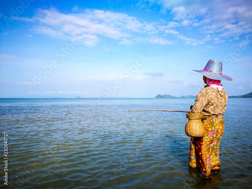 A woman wear sarong standing in the sea to fishing photo