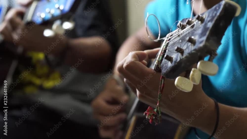 Young man strumming guitar. Close up, Shallow Depth of Field, Selective Focus Young man strumming guitar. Close up, Shallow Depth of Field, Selective Focus