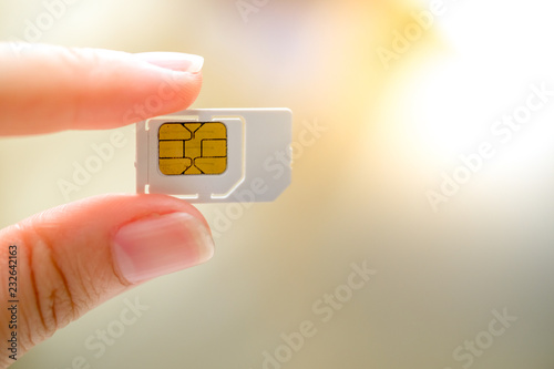 Hand holding white sim card.