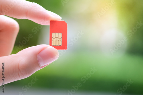 Hand holding red sim card. photo