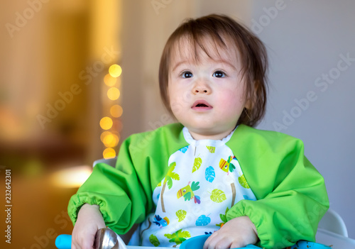 Toddler boy eating food in the kitchen