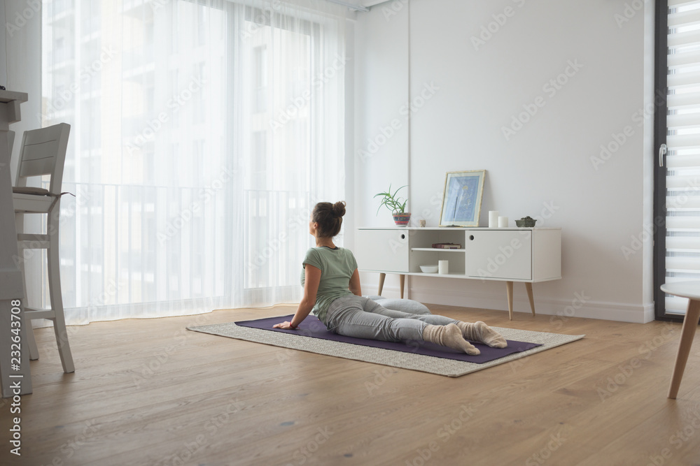 Back view of woman practicing yoga at home Back view of woman practicing yoga at home