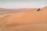 aeril view of Liwa desert, dune buggy driving down a dune