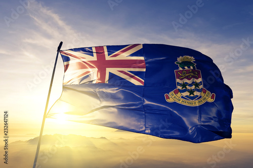 Cayman Islands Caymanian flag textile cloth fabric waving on the top sunrise mist fog