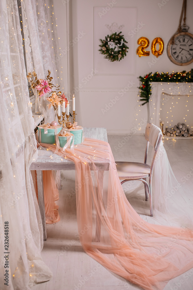 Christmas holiday composition a group of gifts on table on the background of garlands and fireplace. New year 2019. Place for text.