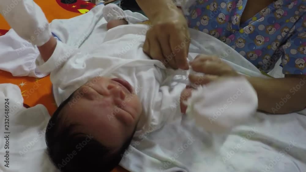 nurse undresses infant boy during pediatric medical checkup nurse undresses infant boy during pediatric medical checkup