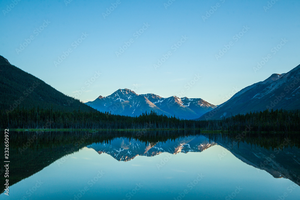 Sunset reflection of mountains on still lake Sunset reflection of mountains on still lake