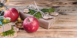 Web banner Christmas background. Red apples, gifts, fir branches and cones on a wooden background