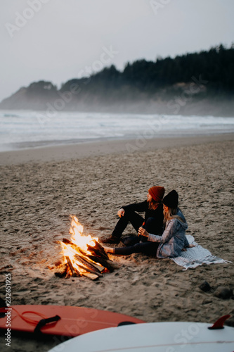 couple has a campfire after surfing photo