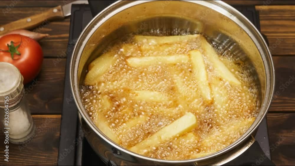 Timelaspe of french fries are deep fried Timelaspe of french fries are deep fried