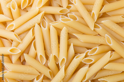 Pennoni uncooked whole wheat penne pasta, top view. Food background.