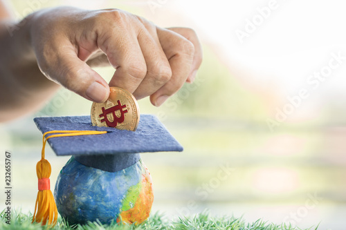 Student hand dropping investing bitcoin money coin to Graduation fund for save moneys in studying abroad. Education savings and investment ideas. Back to School, Studies lead to success for knowledge photo