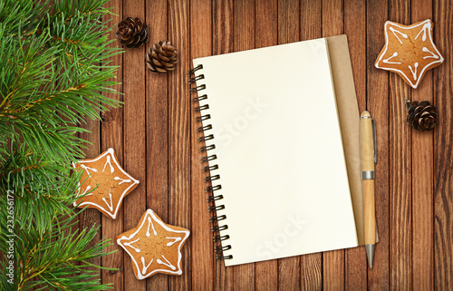 Notepad and a pencil with Christmas decorations and cookies photo