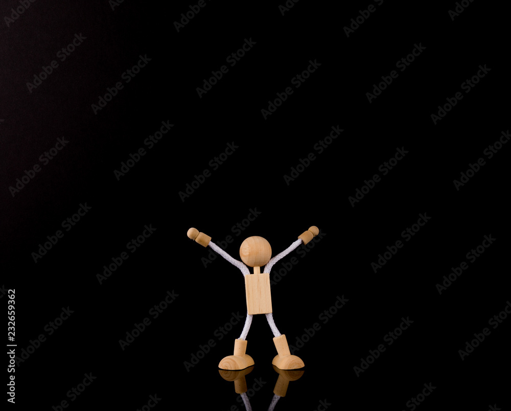 Wooden Stick Figure arms up, isolated on black background, copy space