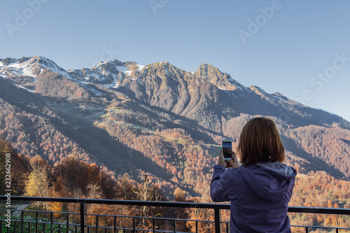 Woman with mobile phone in mountains. Rosa Khutor. photo