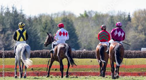 horse riders on the race track infront of a hurdle jump © Gabriel Cassan