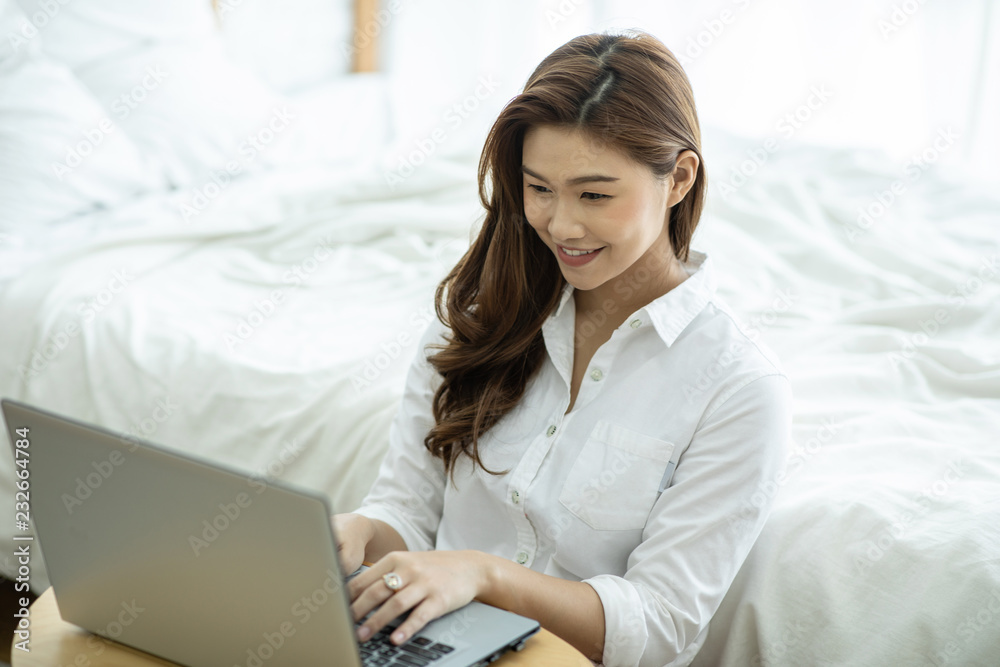 Lifestyle of Beautiful Attractive Asian woman smile working or shopping online with computer laptop in bedroom feeling so happiness and cheerful,Relax in holiday with laptop and using social network Lifestyle of Beautiful Attractive Asian woman smile working or shopping online with computer laptop in bedroom feeling so happiness and cheerful,Relax in holiday with laptop and using social network