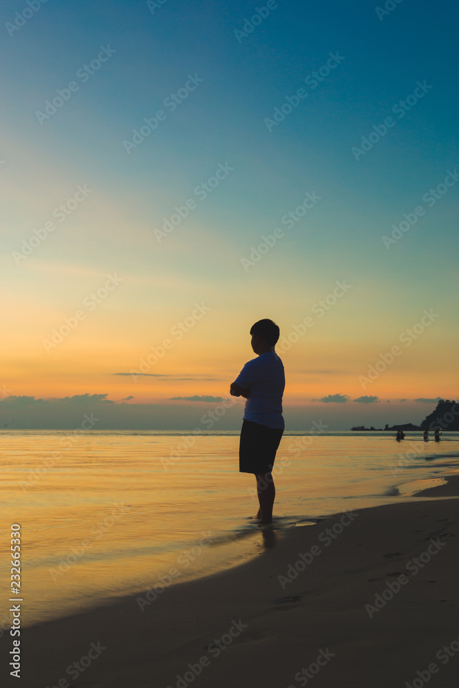 One man stands alone in the ocean. Silhouette style Vertical
