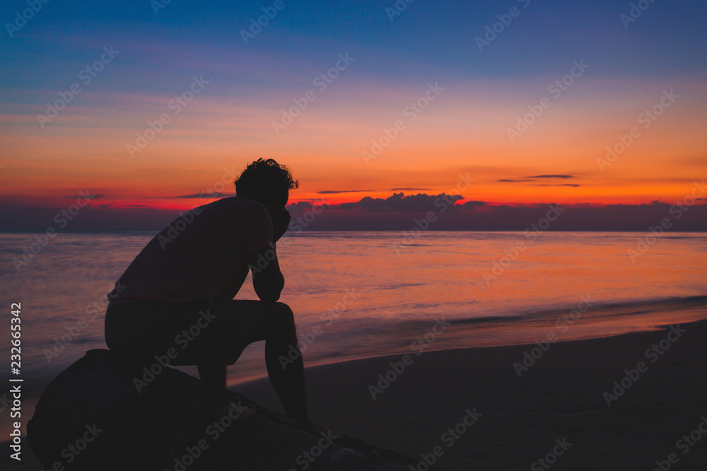 Fototapeta premium man alone Lonely by the ocean. At the time the sun