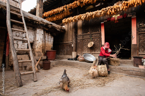 Chinese senior man making a corn chair at his yard. photo