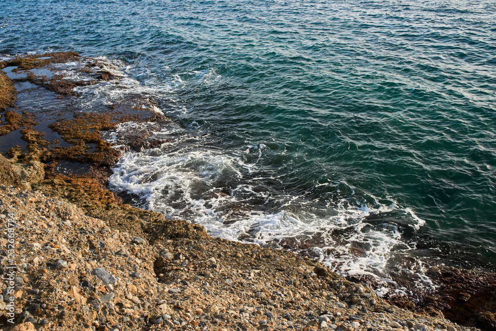 Aerial top view of sea waves hitting rocks on the beach with turquoise sea water. Amazing rock cliff seascape in the coastline. Aerial view of sea waves and fantastic Rocky coast. Mediterranean Sea. Aerial top view of sea waves hitting rocks on the beach with turquoise sea water. Amazing rock cliff seascape in the coastline. Aerial view of sea waves and fantastic Rocky coast. Mediterranean Sea.