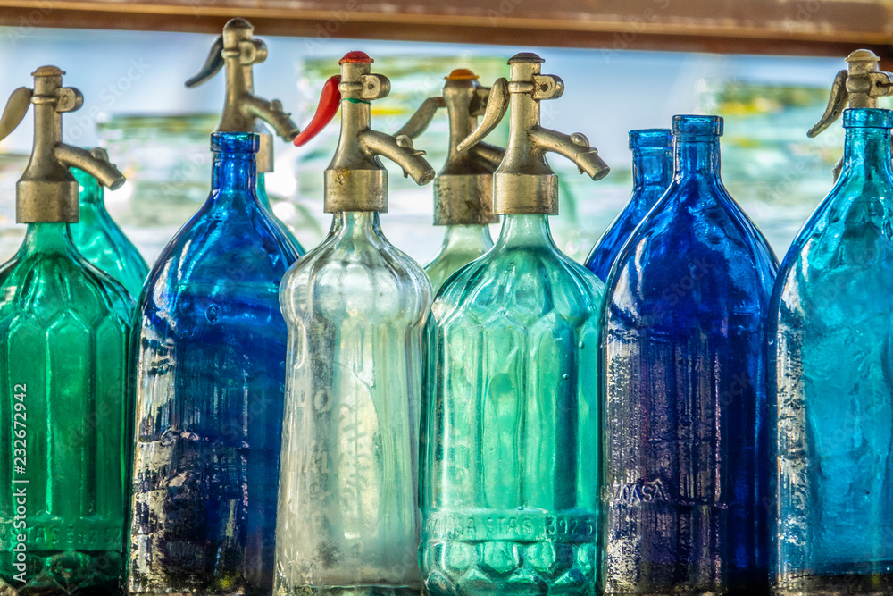 Foto Stock Vecchie bottiglie per il seltz in vetro colorato | Adobe Stock