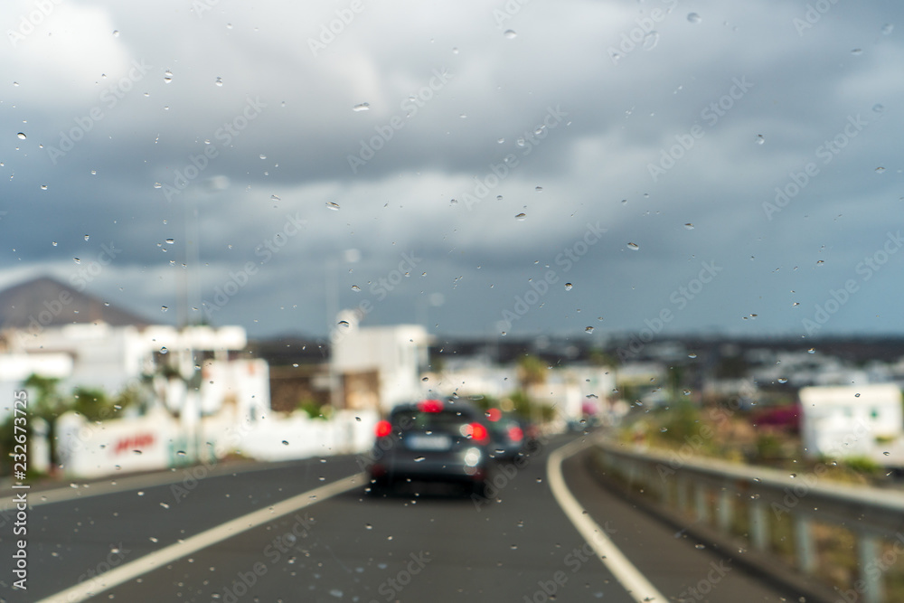 Water droplets on a windshield with a blurred traffic background. Water droplets on a windshield with a blurred traffic background.