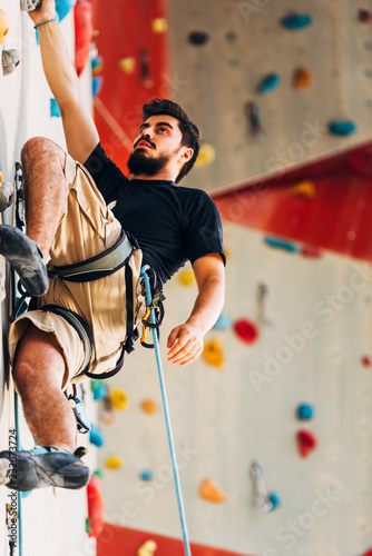 Sport man hanging extreme sport climbing wall in outdoor gym