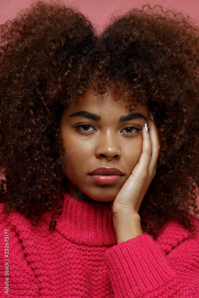Portrait of a young African American afro woman in pink studio Portrait of a young African American afro woman in pink studio