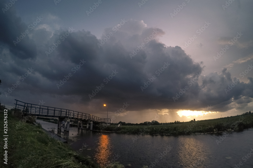 Obraz premium Bridge with stormcloud at sunset