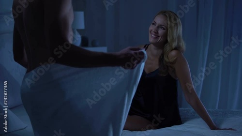 Sexy lady laughing on bed, sexy handsome boyfriend coming in towel, foreplay
