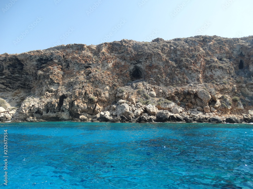 the rocky shores of Cyprus on the Mediterranean Sea in the summer during a family holiday and sailing on a yacht in 2018