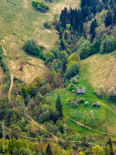 Looking down from the mountain to the small farm house, the forest and lines of roads