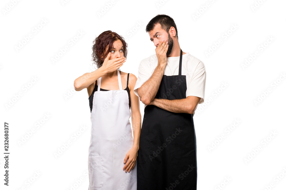 Fototapeta premium Couple of cooks covering mouth with hands for saying something i on isolated white background