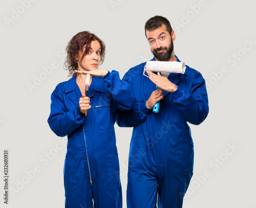 Painters making stop gesture with her hand to stop an act on isolated grey background