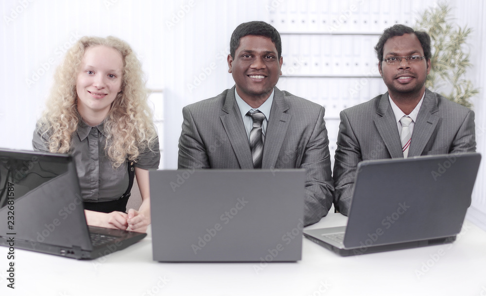 employees sitting in front of open laptops. isolated on white employees sitting in front of open laptops. isolated on white