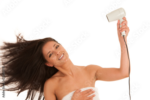 Beautiful young woman drying hair with hair dryer isolated over white background