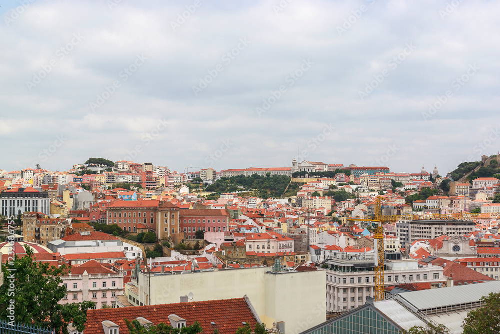 View of the Lisbon from the viewpoint Miradouro de Sao Pedro de Alcantara. Sightseeing In Portugal. Orange roofs of the old town.