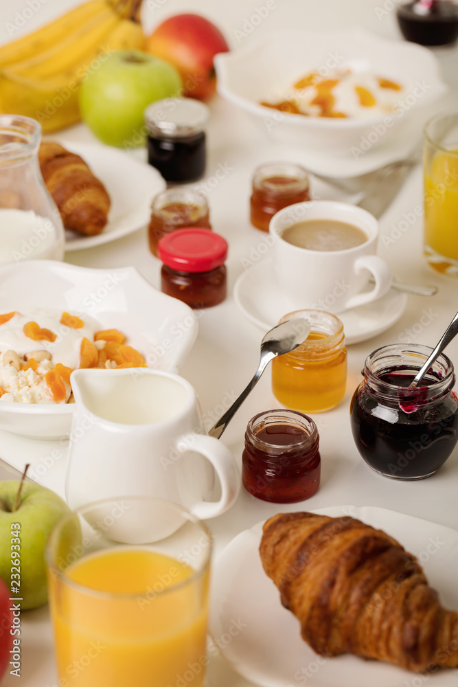 Breakfast time. Croissants and orange juice, jam and honey. Coffee with cream or milk. Fruits - bananas, red and green apples. Ricotta with sour cream, nuts and dried apricots. Breakfast time. Croissants and orange juice, jam and honey. Coffee with cream or milk. Fruits - bananas, red and green apples. Ricotta with sour cream, nuts and dried apricots.