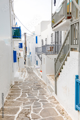 Fototapeta Naklejka Na Ścianę i Meble -  Traditional houses with blue doors and windows in the narrow streets of greek village in Mykonos, Greece
