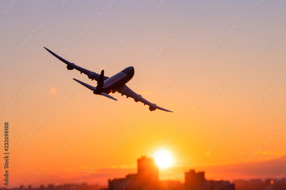 Airplane flying above in the sunset with skyscrapers. Transportation and travel, destination. Turn right.