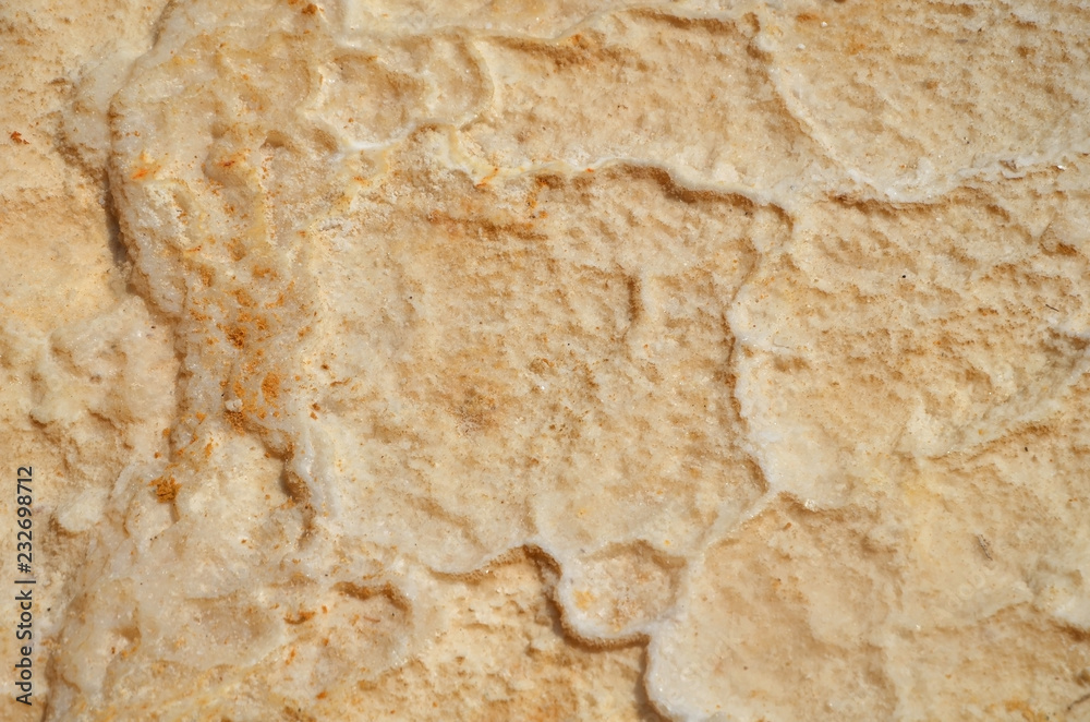 The texture of the dried salt mixed with orange sand. The bottom of the Dead Sea in Israel, the sea dries up and disappears. The texture of the dried salt mixed with orange sand. The bottom of the Dead Sea in Israel, the sea dries up and disappears.