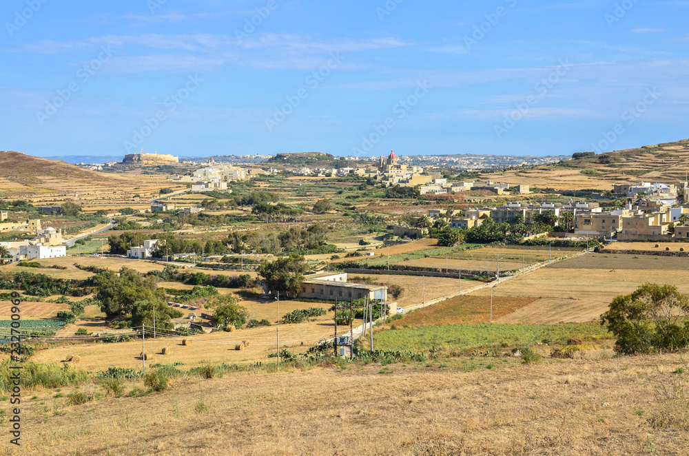 The agricultural countryside landscape of Gozo with the citadel of Victoria in the far distant, Malta