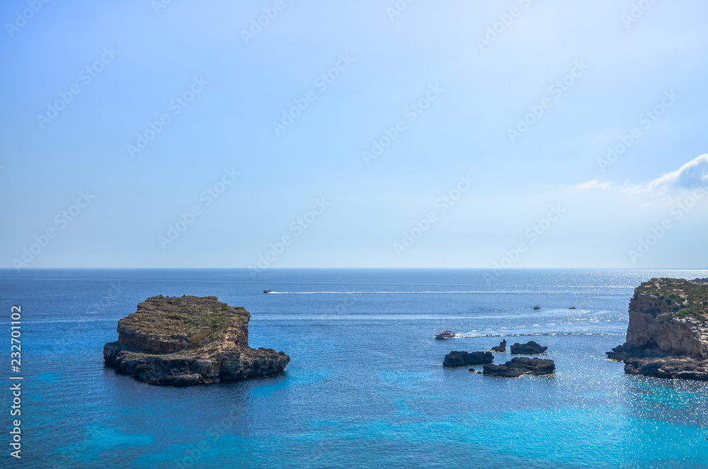 Rocks and tourism at the Blue Lagoon in the Mediterranean Sea, Comino Island, Malta